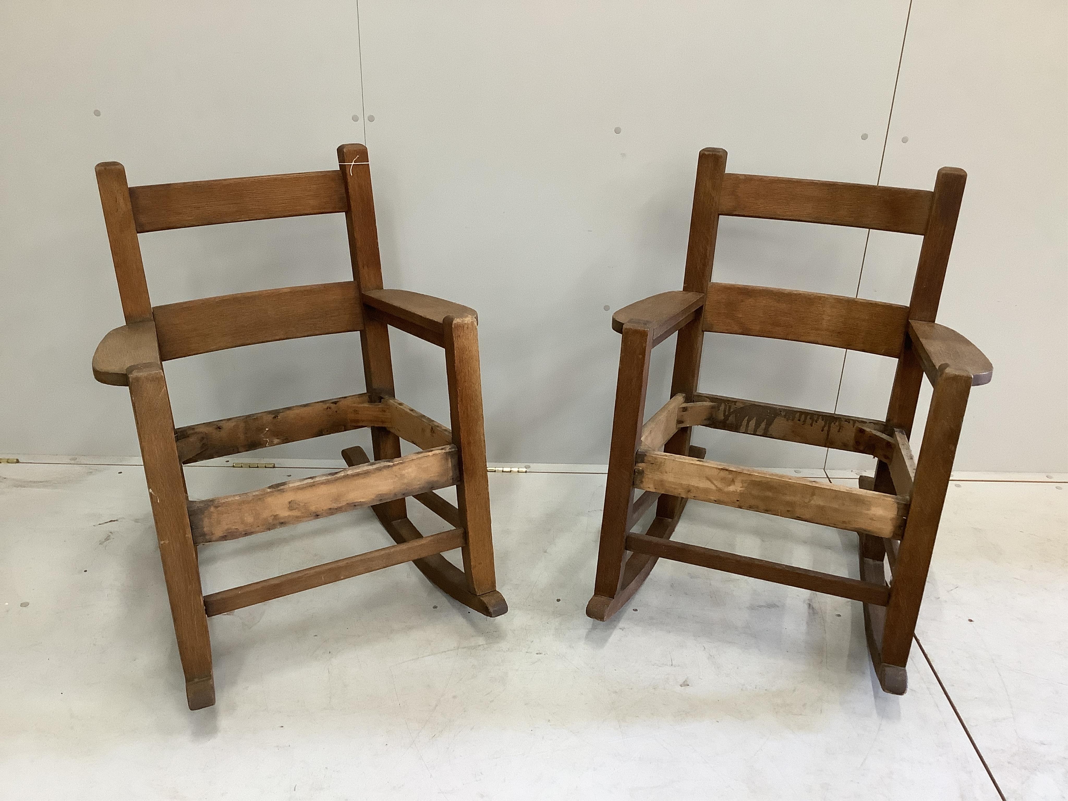 In the manner of Stickley, a pair of Arts and Crafts oak rocking chairs, width 69cm, depth 78cm, height 89cm